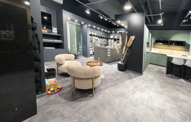 Beratungsecke und grüne L-Küche mit Tresen im Küchenstudio Die Küchengalerie