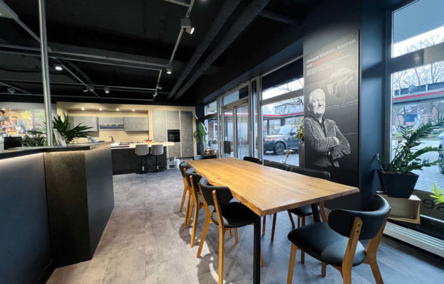 Eingangsbereich des Kcühenstudio: Großer Holzesstisch und Bedienungstresen.