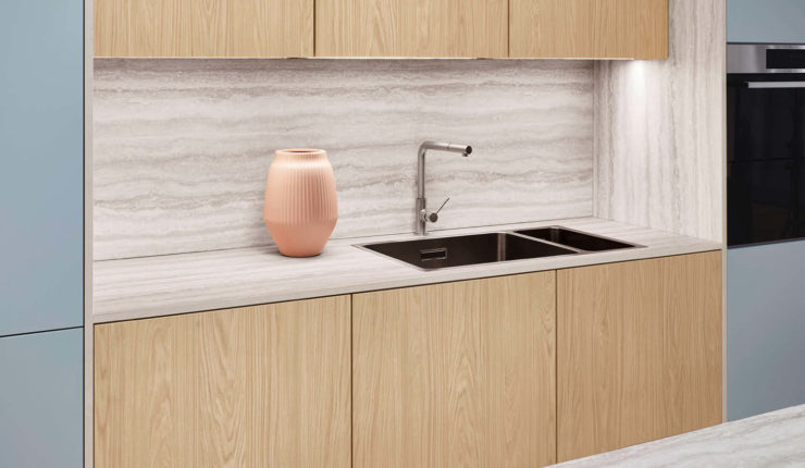 Blaue Küchenzeile mit Holz Unter- und Oberschränken. Arbeitsplatte und Nischenrückwand in heller Holzoptik.