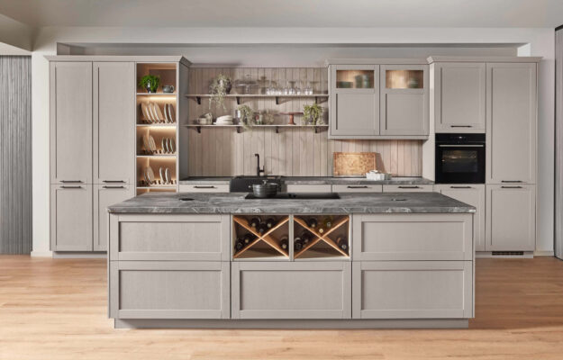 Nobilia Landhausküche in elegantem Greige mit klassischer Kassettenoptik, offenen Regalen und stilvoll integrierter Beleuchtung für ein zeitlos wohnliches Ambiente