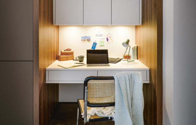 Schüller Home-Office-Lösung mit integrierter Schreibtischnische, warmen Holzdetails und durchdachter Beleuchtung für konzentriertes Arbeiten auf kleinem Raum