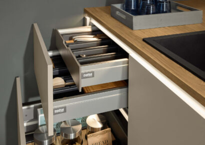 Nolte Küchenschublade mit organisiertem Besteckeinsatz und Auszugssystem, funktionales Stauraumdesign in moderner Küche mit Holzarbeitsplatte
