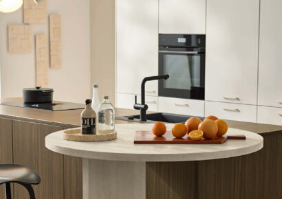 Nolte Küche mit hochwertigen Materialien wie Holz, Lack und Glas, kombiniert moderne Technik, funktionale Kücheninsel und durchdachtes Design für effizientes Arbeiten